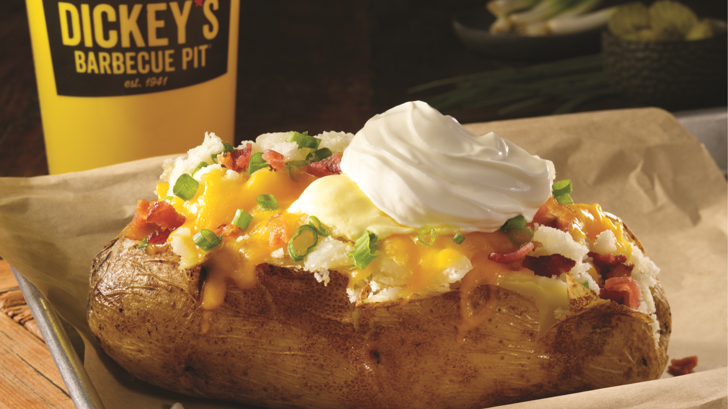 Dickey&rsquo;s Barbecue Pit Giant Pit-Smoked Loaded Baker topped with cheese, bacon, green onion and sour cream